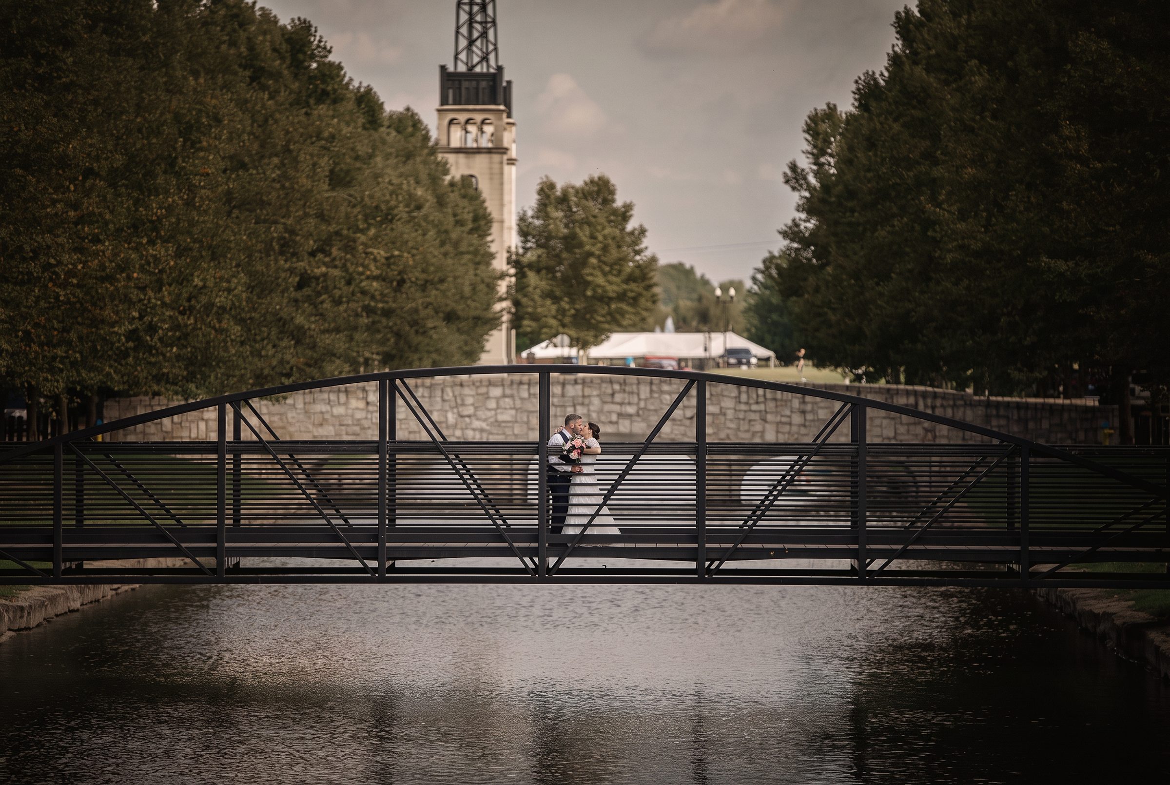 Bride and groom kissing on a footbridge