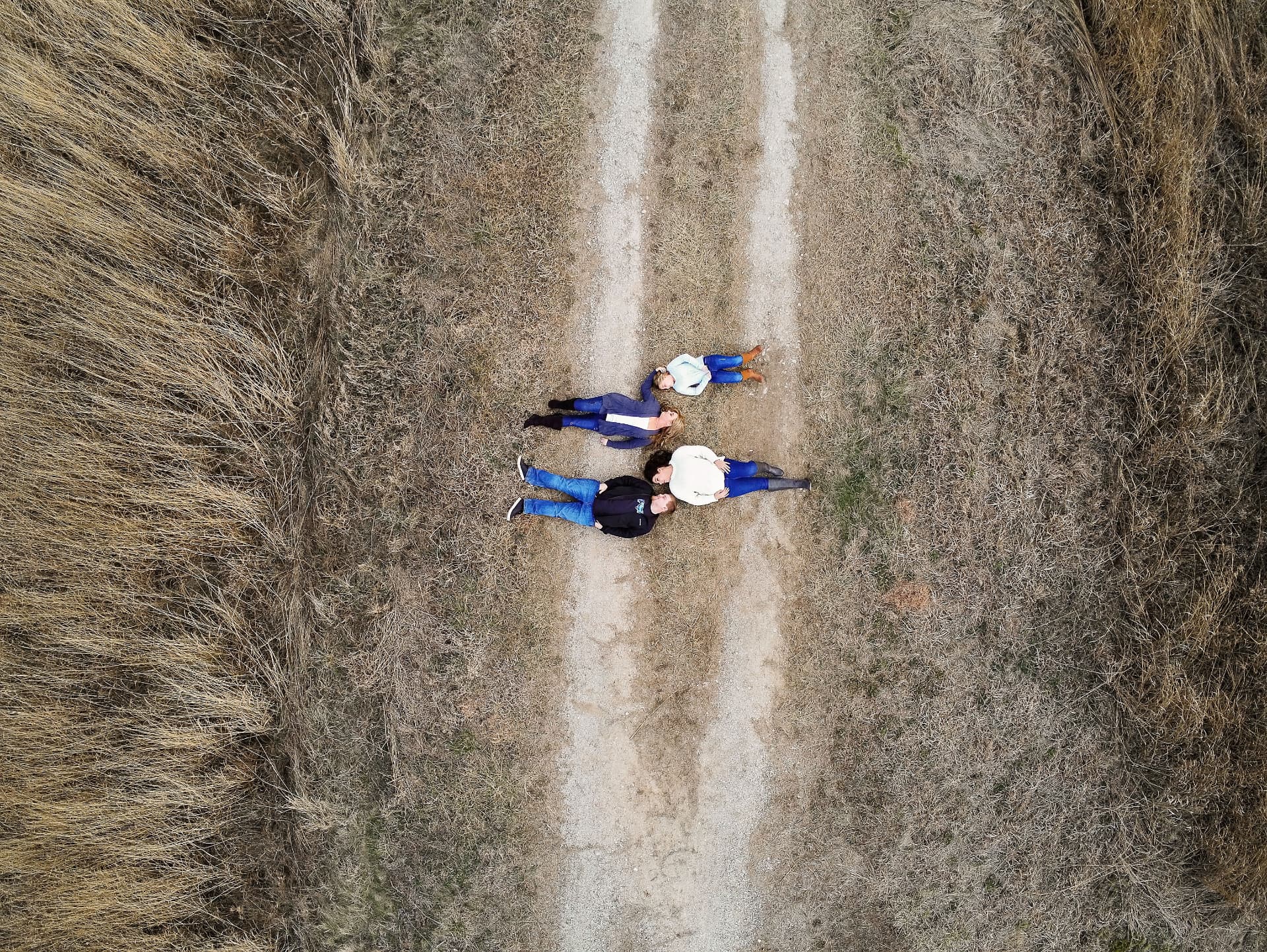 Overhead view of a family lying together on a gravel country road