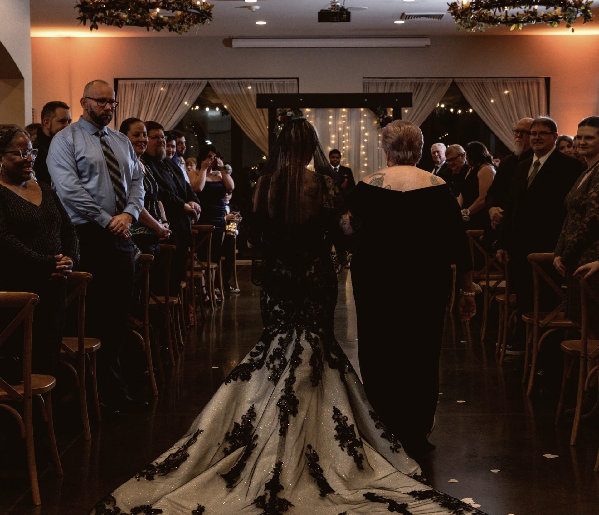 Bride walking the aisle of a dim ceremony room