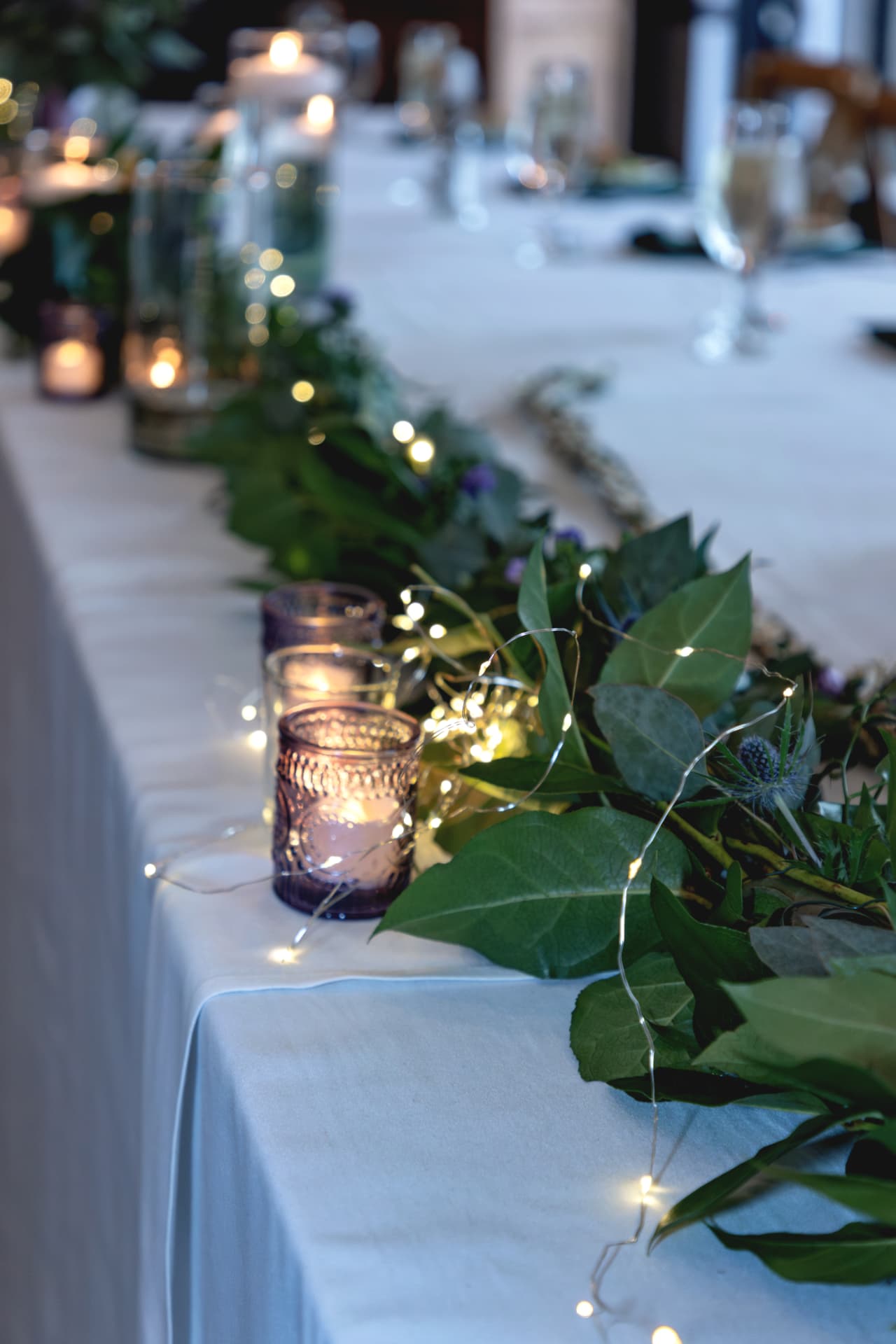 Reception head table with greenery and candles