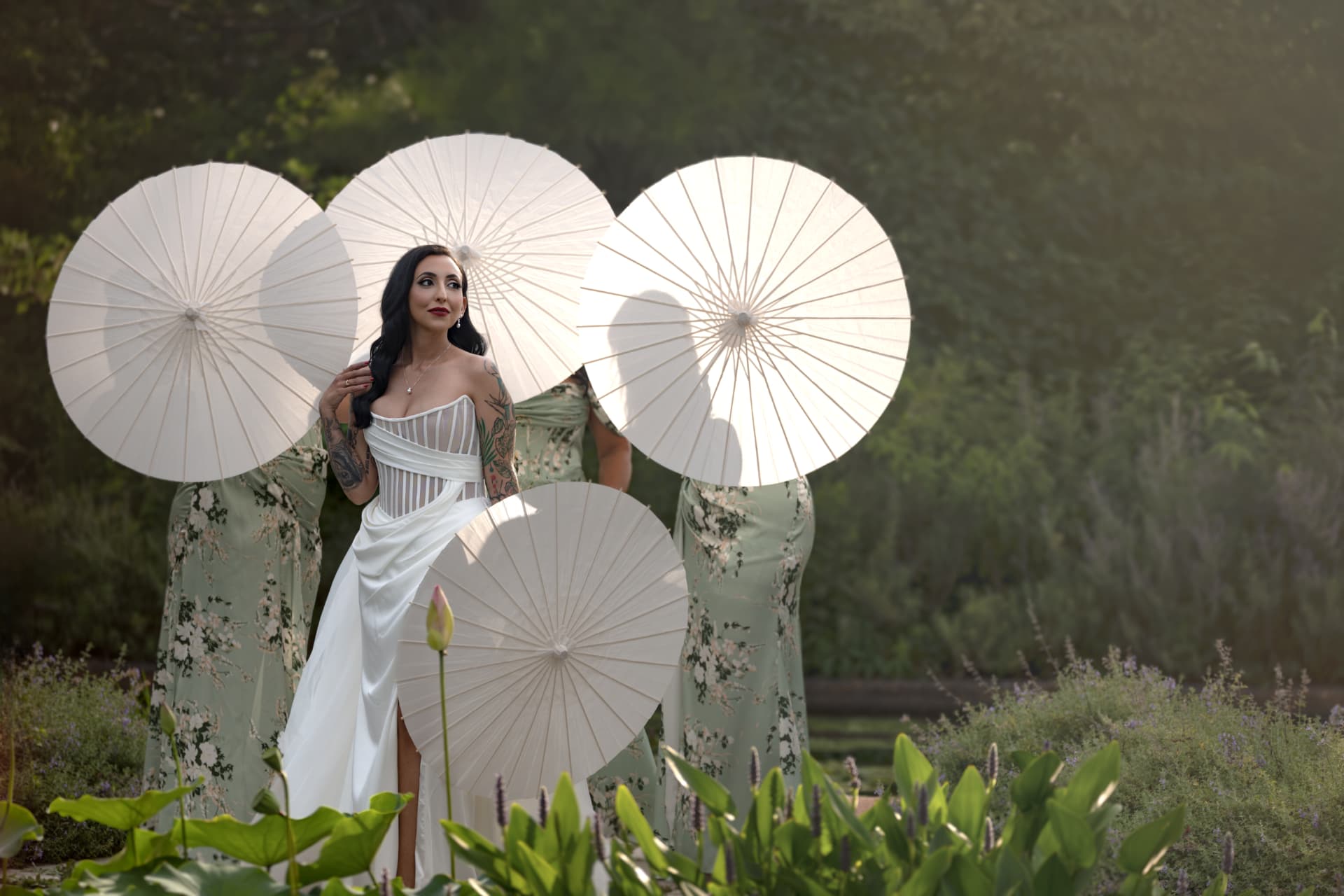 Bride holding a paper parasol surrounded by her bridesmaids with parasols