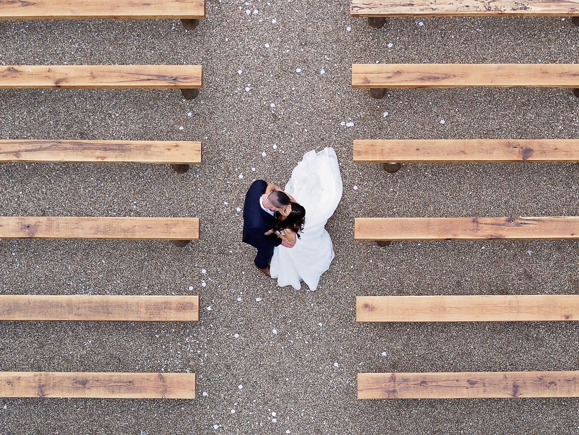Overhead view of a couple kissing between the pews after the ceremony at Redemption Ranch