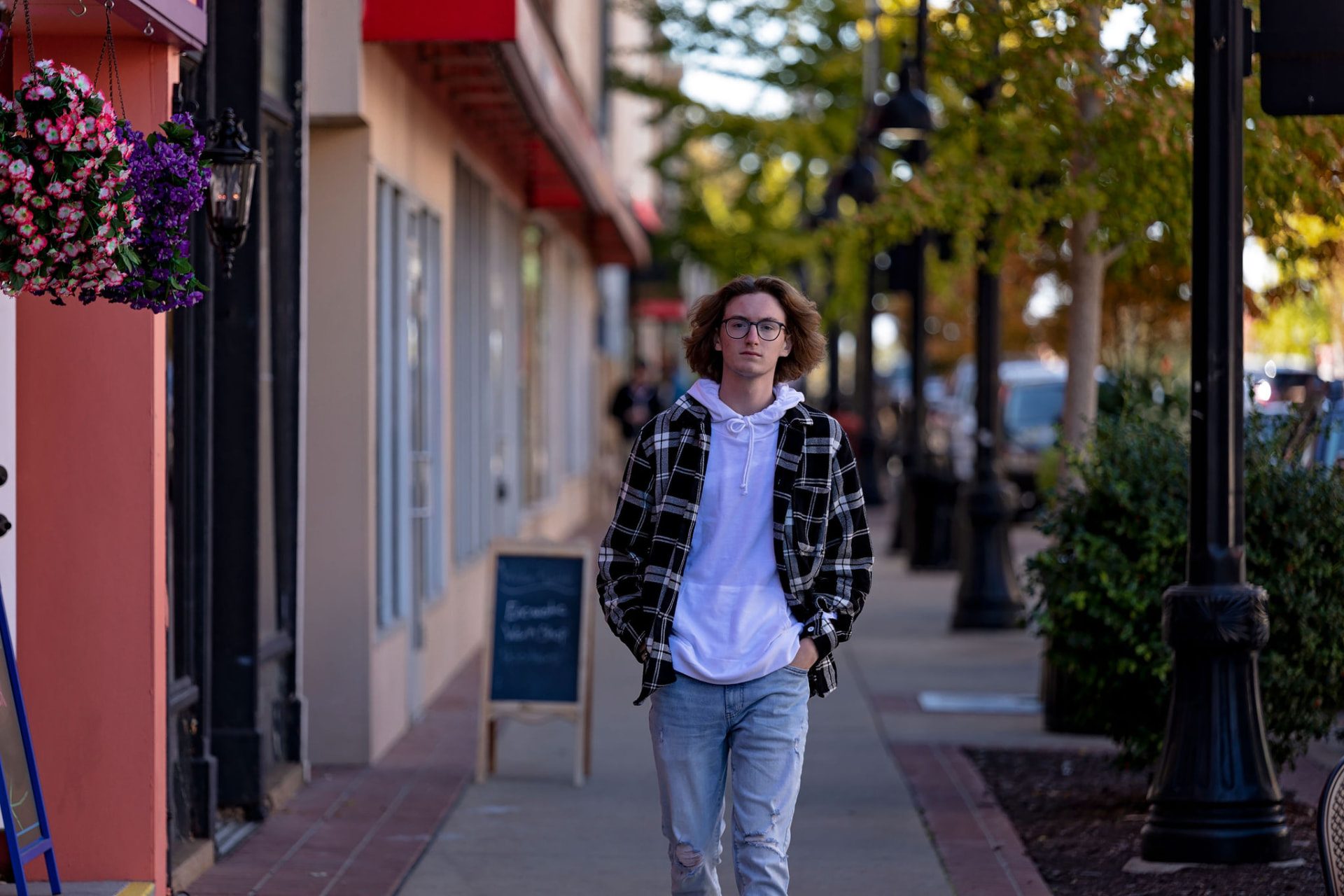 Senior walking down a downtown sidewalk in a flannel