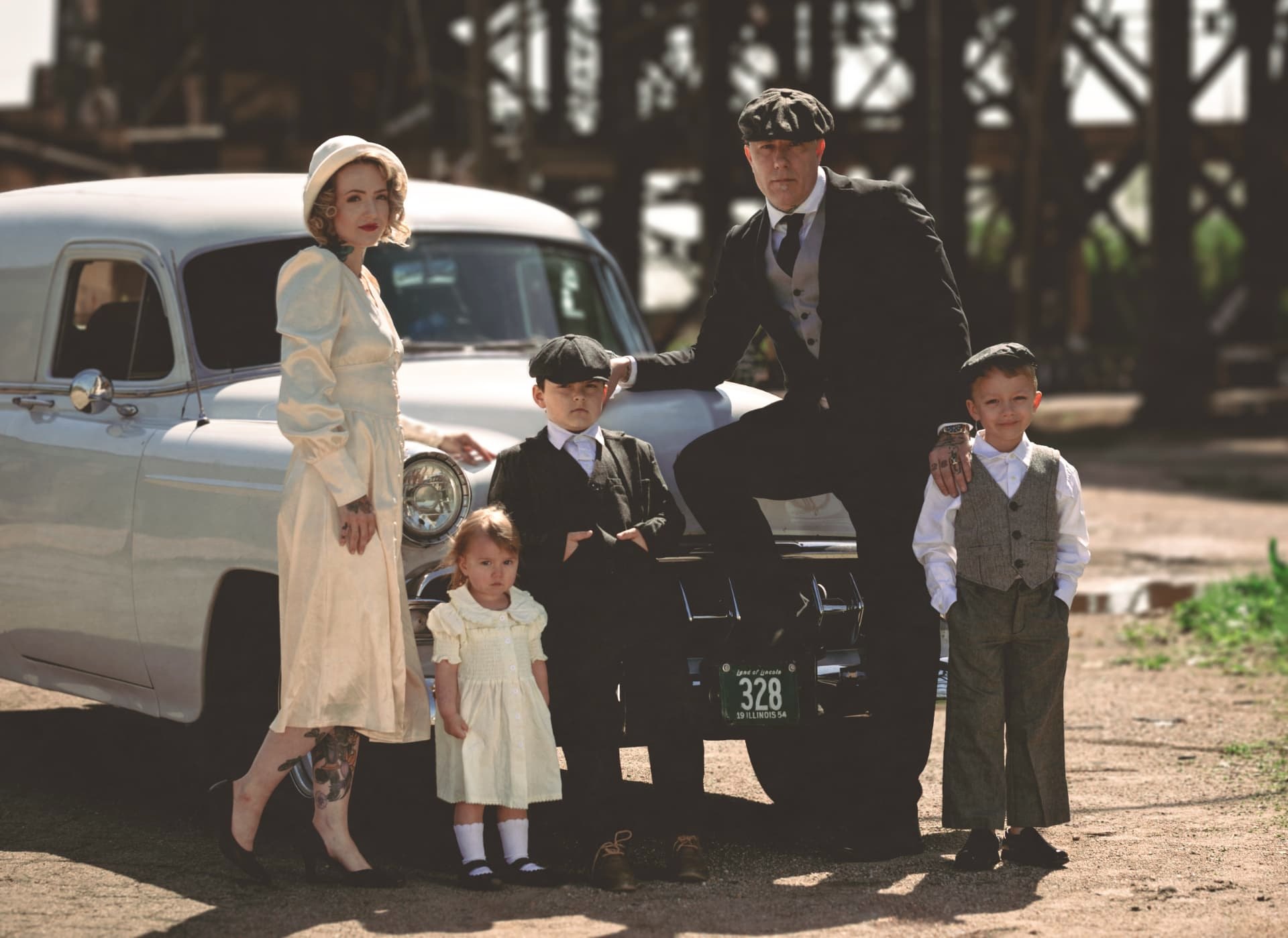 Family of five posed in front of a vintage white car