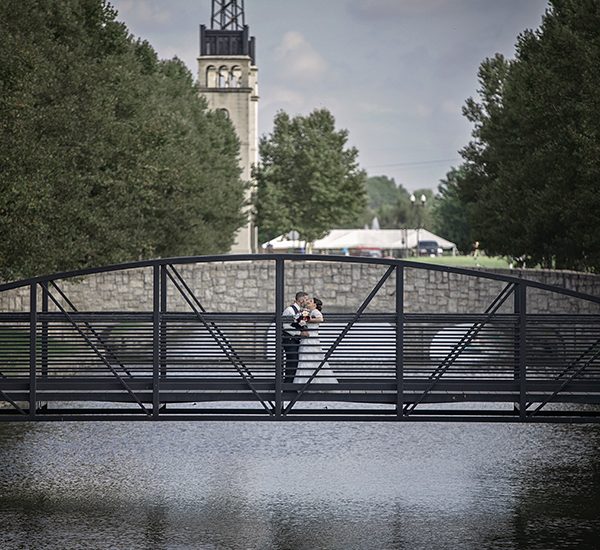 Shane Michael Studios Wedding Photography of bride and groom standing on a bridge overlooking a lake