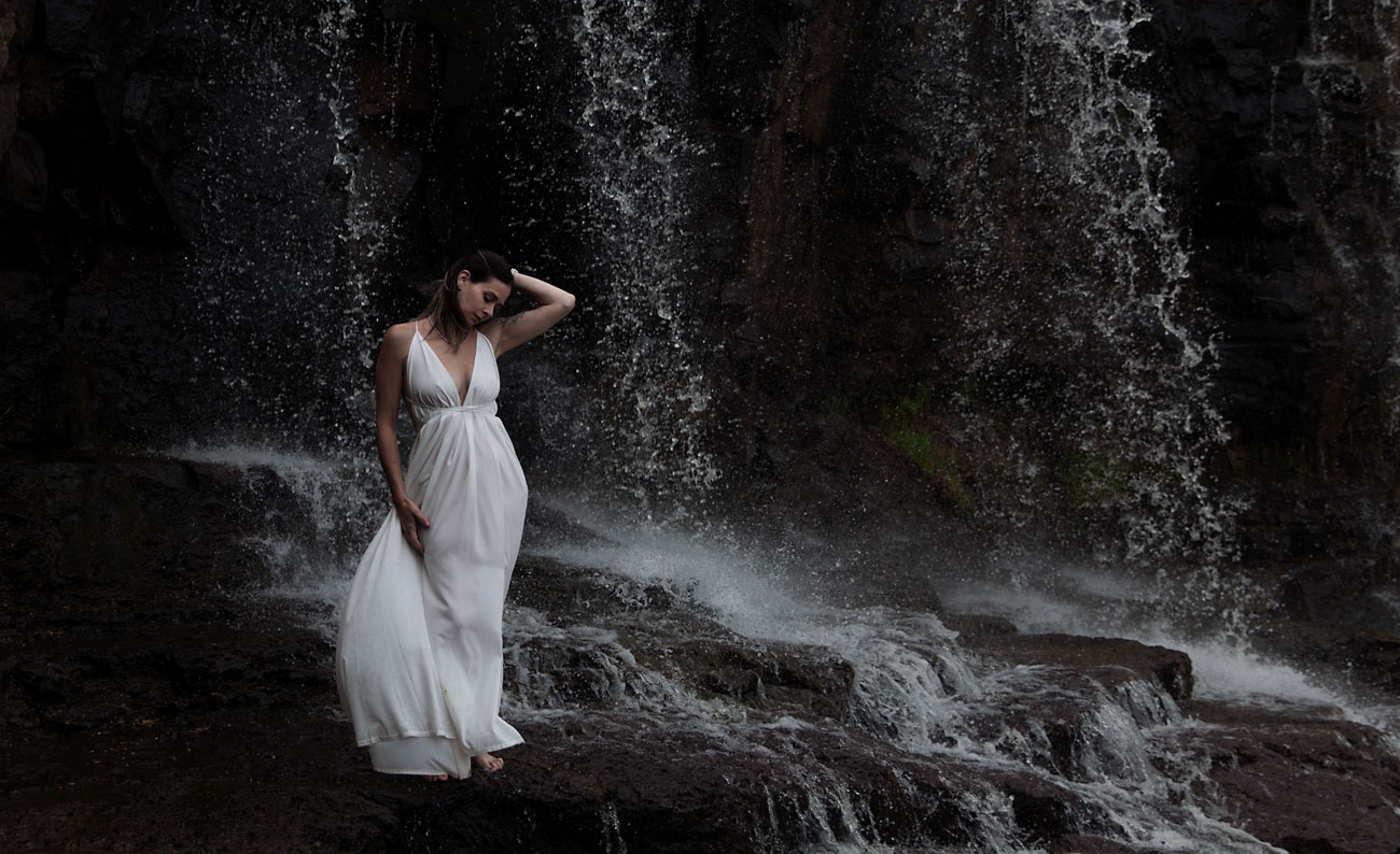 Bride standing in front of a waterfall